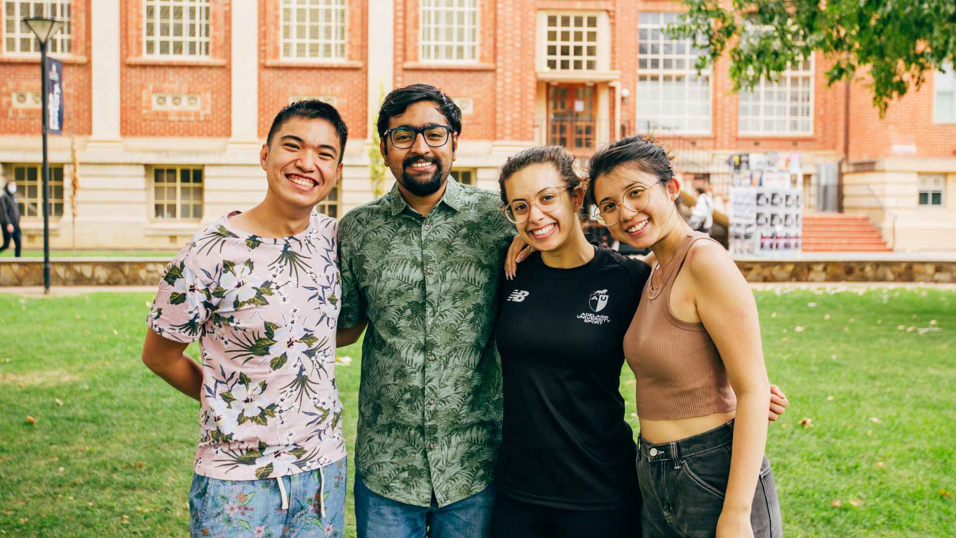 2022 Student Experience Directors stand arm in arm on the Barr Smith Lawns. Pictured from left to right is Ryan, Sagaar, Aletha and Maxine
